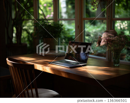 Home office setup with wooden desk and laptop near window in a bright room with plants and flowers 136366501