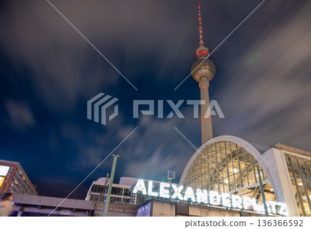 Berlin, germany, august 12, 2023. Berlin cityscape at night with illuminated fernsehturm and alexanderplatz station under streaking clouds, long-exposure urban glow Berlin, germany, august 12, 2023. Berlin cityscape at night with illuminated fernsehturm and alexanderplatz station under streaking clouds, long-exposure urban glow 136366592
