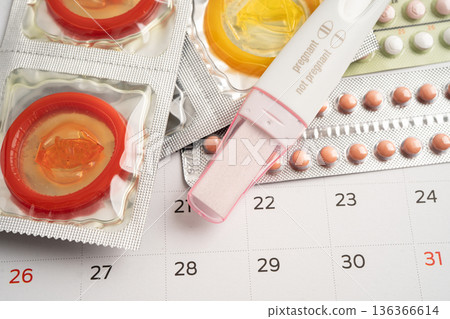 Pregnancy test and birth control pills on calendar, contraception health and medicine. 136366614