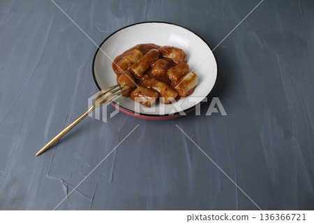 Meat sausages in tomato sauce, ketchup in a plate, next to a fork for food with space for textk copyspace. Meat sausages in tomato sauce, ketchup in a plate, next to a fork for food with space for textk copyspace. 136366721