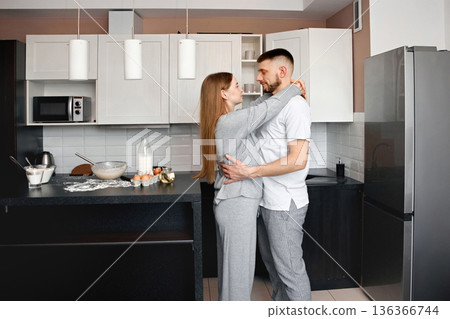 Couple cooking together in modern kitchen showing love and connection during morning time in cozy home setting Couple cooking together in modern kitchen showing love and connection during morning time in cozy home setting 136366744