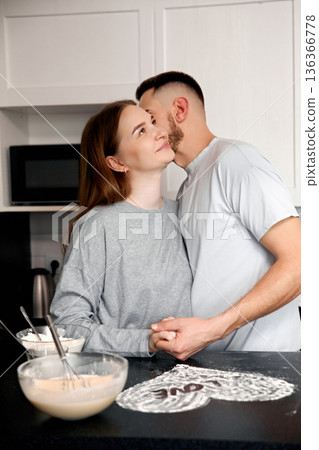 Couple in kitchen shares a moment while preparing food together on a weekend afternoon 136366778