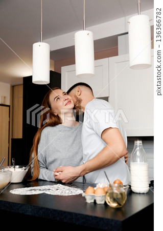 Couple shares a joyful moment in kitchen while preparing breakfast in morning light on weekend at home Couple shares a joyful moment in kitchen while preparing breakfast in morning light on weekend at home 136366782