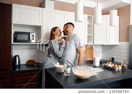 Couple shares a moment in the kitchen while preparing breakfast together in a modern home on a weekend morning 136366784