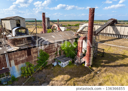 Old phosphate processing plant in central Florida with weathered structure, conveyor belts and overgrown vegetation. Old phosphate processing plant in central Florida with weathered structure, conveyor belts and overgrown vegetation. 136366855