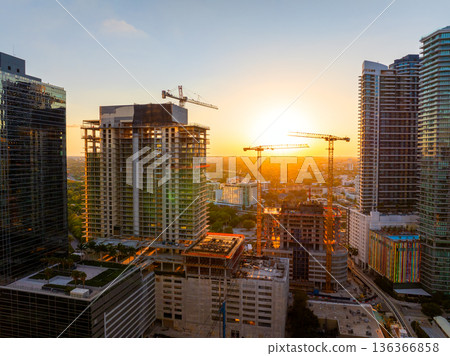 Aerial view of new developing residence in American urban area at sunset. Tower cranes at industrial construction site in Miami, Florida. Concept of housing growth in the USA 136366858