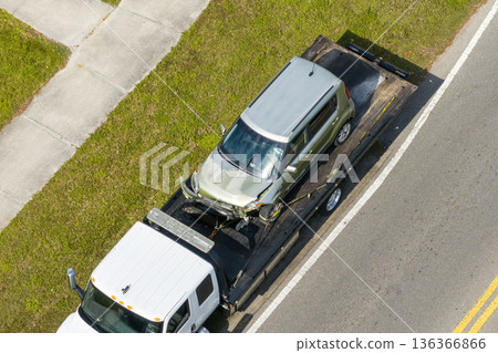 First responders helping on car accident site. Tow truck loading crashed car. Emergency services responding to vehicle crash on American street 136366866