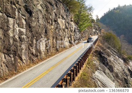 Scenic journey through Highlands Road in North Carolina. Rocky mountainsides and fall forest canopy create a stunning autumn drive. Scenic journey through Highlands Road in North Carolina. Rocky mountainsides and fall forest canopy create a stunning autumn drive. 136366870