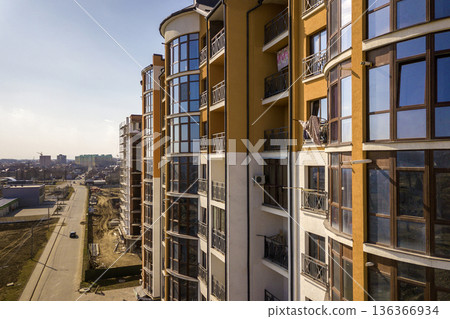 New tall apartment buildings and parked cars and suburb houses on blue sky copy space background. New tall apartment buildings and parked cars and suburb houses on blue sky copy space background. 136366934