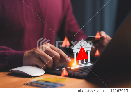 Cybersecurity warning concept showing hand using laptop and credit card with alert icons and bank symbol, representing online banking fraud, phishing scam, and financial data protection. Cybersecurity warning concept showing hand using laptop and credit card with alert icons and bank symbol, representing online banking fraud, phishing scam, and financial data protection. 136367065