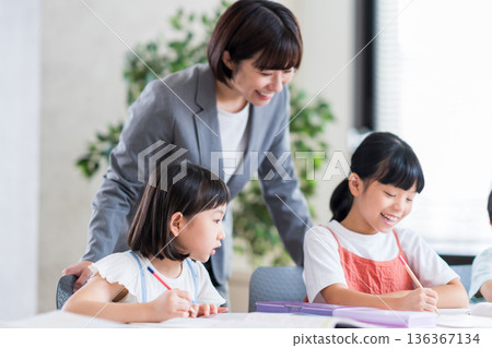Elementary school students studying at cram school. 136367134