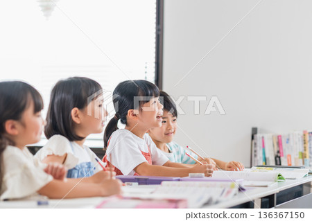 Elementary school students studying at cram school. 136367150