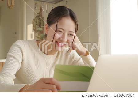 一位女士正在查看她的銀行存摺來管理她的錢。 136367594