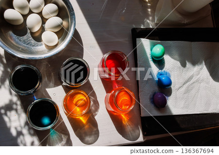 Easter egg dyeing setup with color jars and dyed eggs on tray. Top view Easter egg dyeing setup with color jars and dyed eggs on tray. Top view 136367694