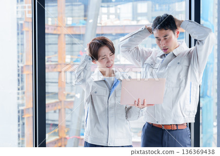 A worker with a troubled expression at a construction site 136369438