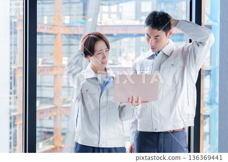 建築工地上，一名表情憂慮的工人 136369441