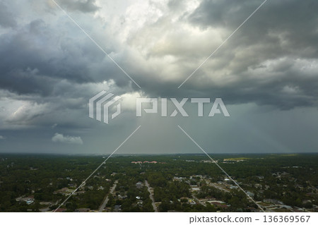 Landscape of dark ominous clouds forming on stormy sky before heavy thunderstorm over rural town area 136369567