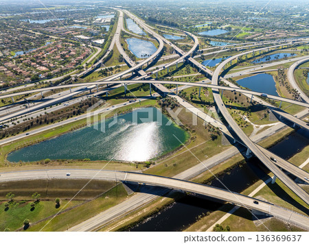 Miami freeway interchange with elevated road lanes for fast express driving of cars. Vehicles driving on huge complex expressway junction 136369637