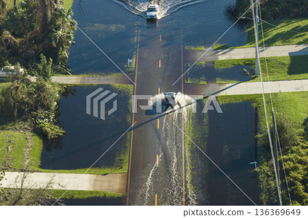Hurricahe fainfall flooded Florida road with evacuating cars and surrounded with water houses in suburban residential area Hurricahe fainfall flooded Florida road with evacuating cars and surrounded with water houses in suburban residential area 136369649
