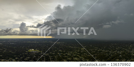 Landscape of dark ominous clouds forming on stormy sky during heavy thunderstorm over rural town area 136370902