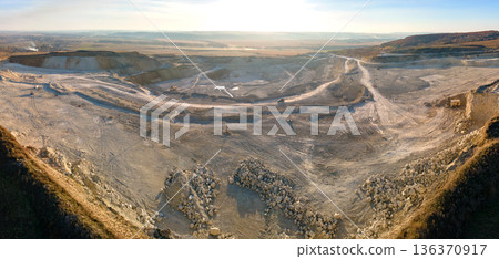 Aerial view of open pit mining site of limestone materials for construction industry with excavators and dump trucks 136370917