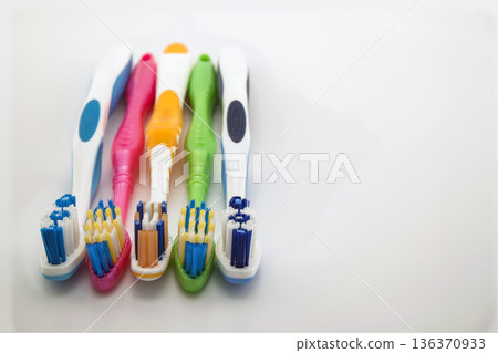 Colorful toothbrushes on white background with copy space. Macro with shallow dof. 136370933