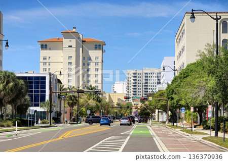 Bike lane in bright green in Sarasota city, Florida. Cars traveling nearby on public road. Urban mobility solutions Bike lane in bright green in Sarasota city, Florida. Cars traveling nearby on public road. Urban mobility solutions 136370936