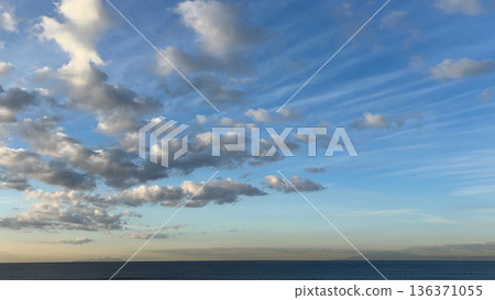 清晨晴空萬裡，白雲飄動，地平線平靜無波。 136371055