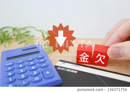 A calculator and bankbook represent a lack of money and a deteriorating household finances. 136371750