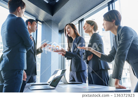 Businessmen and women arguing at a meeting 136372923