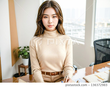 一位年輕女子坐在辦公桌前的自然肖像 136372983