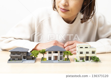 A woman comparing house models 136373120