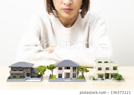 A woman comparing house models A woman comparing house models 136373121