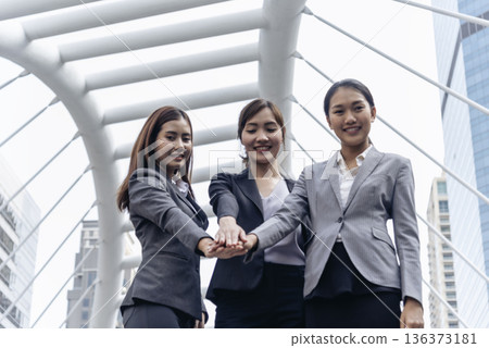 Woman Partners hands together teamwork group of business people meeting in modern city outdoor. Females Hands join empower partnership teams connection community.  Mergers acquisitions partnership 136373181