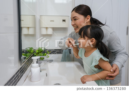 mother teaching girl child to brushing teeth in bathroom mother teaching girl child to brushing teeth in bathroom 136373280