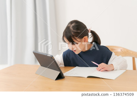 一名小學生正在用平板電腦學習。 136374509