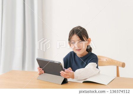 一名小學生正在用平板電腦學習。 136374512