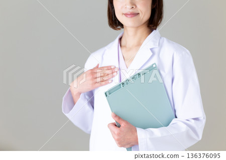 身穿白大褂的中年女護士 身穿白大褂的中年女護士 136376095