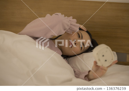 A woman watching a smartphone in bed 136376239