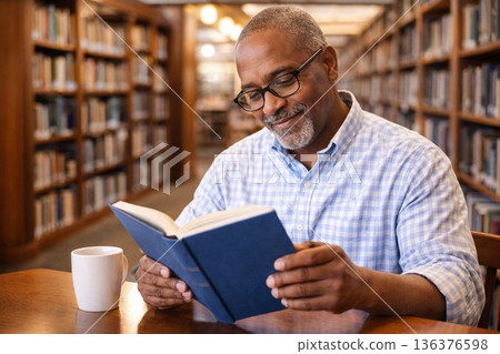 讀一本書的一個人在圖書館裡 136376598