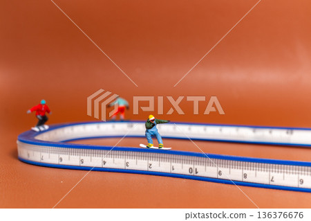 Creative Sport Concept with Snowboarders on Measuring Tape 136376676