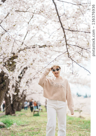 Woman tourist sightseeing Sakura Cherry Blossom in Spring. Happy traveler travel near Hinokinai River riverbank in Kakunodate town, Semboku District, Akita Prefecture, Japan. Landmark and Vacation Woman tourist sightseeing Sakura Cherry Blossom in Spring. Happy traveler travel near Hinokinai River riverbank in Kakunodate town, Semboku District, Akita Prefecture, Japan. Landmark and Vacation 136376936