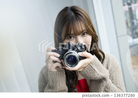 年輕女子正在用單眼相機拍照 136377280