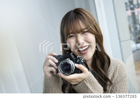 年輕女子正在用單眼相機拍照 年輕女子正在用單眼相機拍照 136377283