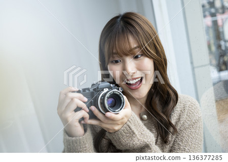 一位年輕女子正在購買單眼相機 136377285