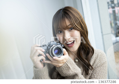 Young woman taking a photo with a SLR camera Young woman taking a photo with a SLR camera 136377286