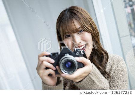 年輕女子正在用單眼相機拍照 136377288