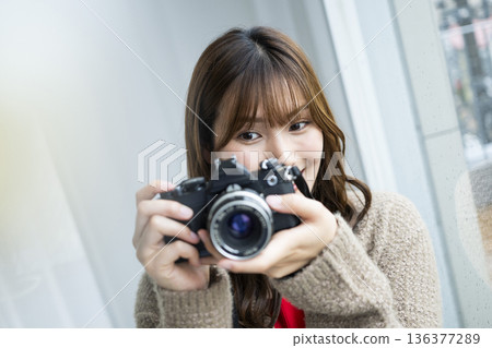 Young woman taking a photo with a SLR camera Young woman taking a photo with a SLR camera 136377289