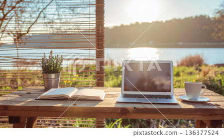 Spring, remote working. Open laptop on wooden table open notebook coffee cup potted plant lakeside cabin sunrise light calm mood remote work Spring, remote working. Open laptop on wooden table open notebook coffee cup potted plant lakeside cabin sunrise light calm mood remote work 136377524
