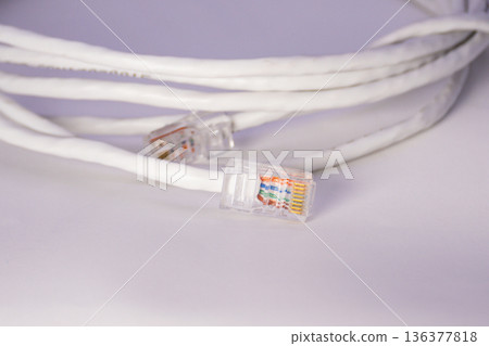Close up of white ethernet cable with RJ45 connector, simple network cable detail for internet connection and basic IT use 136377818